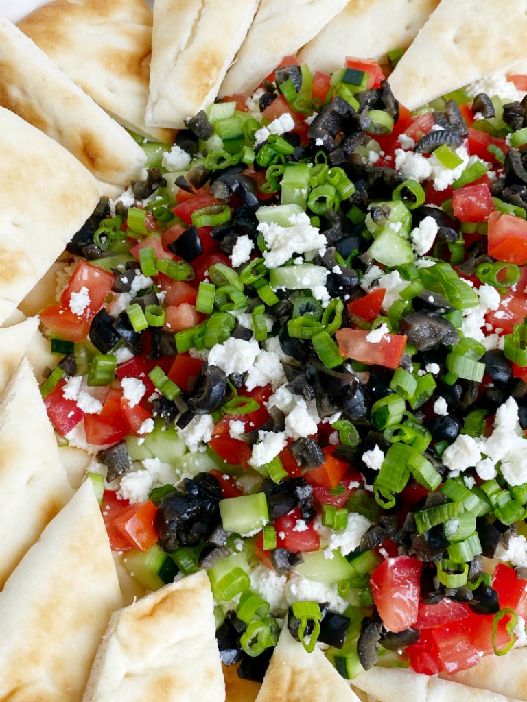 Greek Dip Recipe | Dip Recipe | Party Dips | Appetizer Recipe | This Greek inspired party dip is the best Dip Recipe you will make! Layers of cream cheese, yogurt, spices, tomatoes, cucumbers, olives, and feta cheese. Serve with crackers and pita bread for an amazing appetizer. #diprecipes #appetizers #superbowlrecipes #greekdip #recipeoftheday