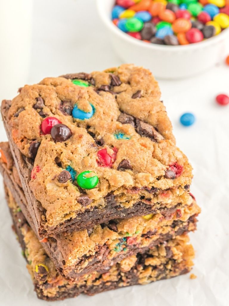 A stack of brownies with cookie dough on a white background.