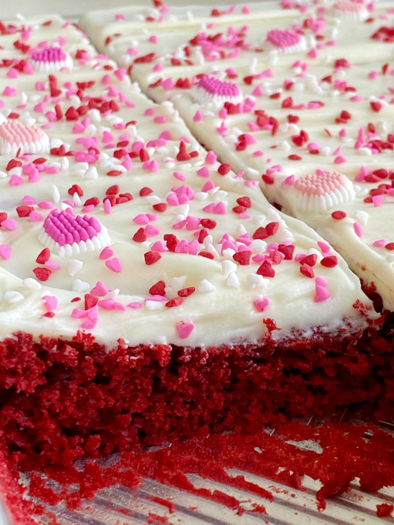 Easy Red Velvet Sheet Cake is so simple to make! A doctored up red velvet cake mix topped with the best, and fluffiest white chocolate cream cheese frosting.