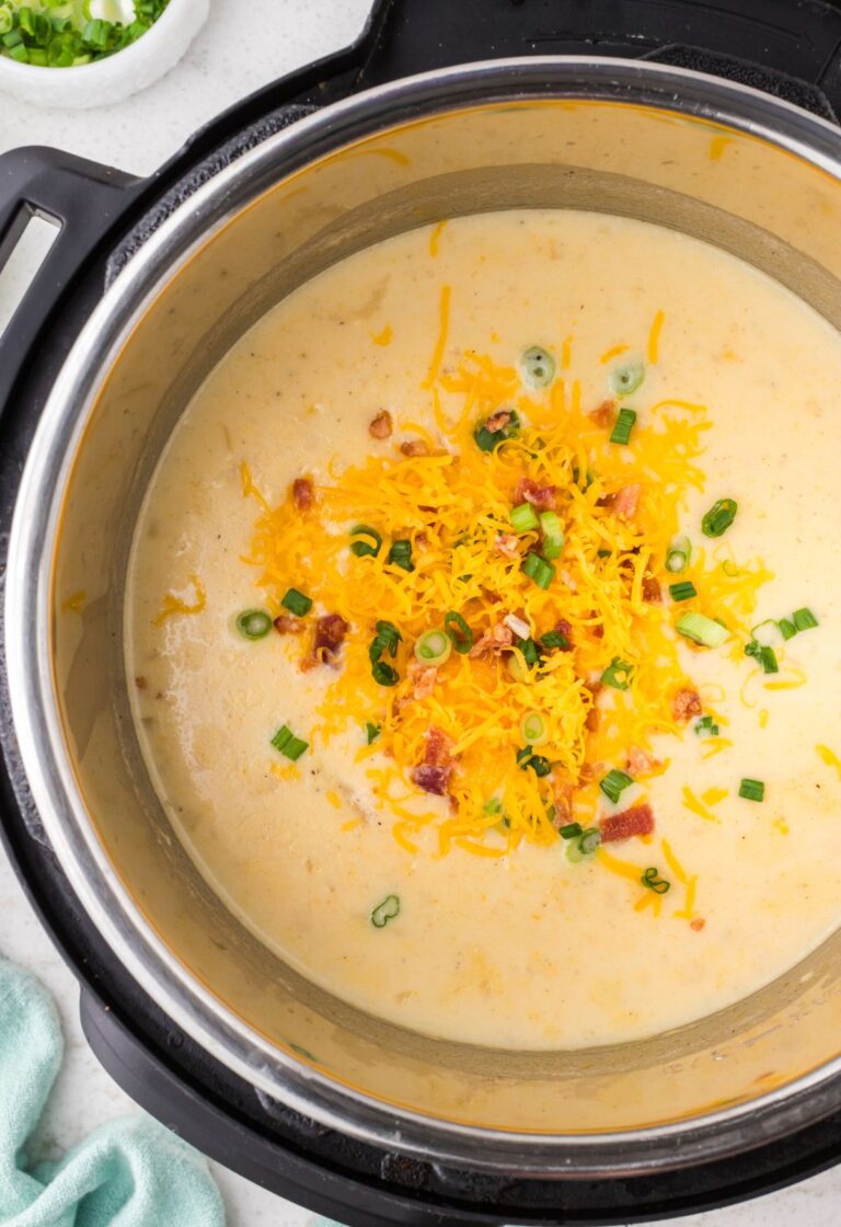 An instant pot with the chowder inside of it and toppings.