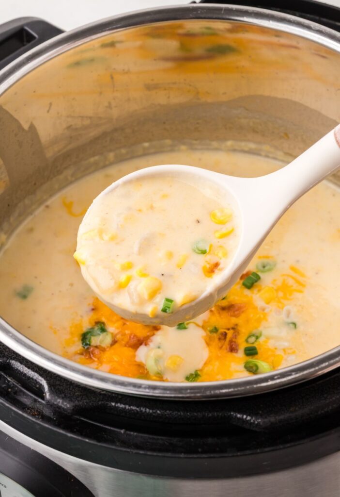 Instant Pot with a soup ladle with some chowder in it.