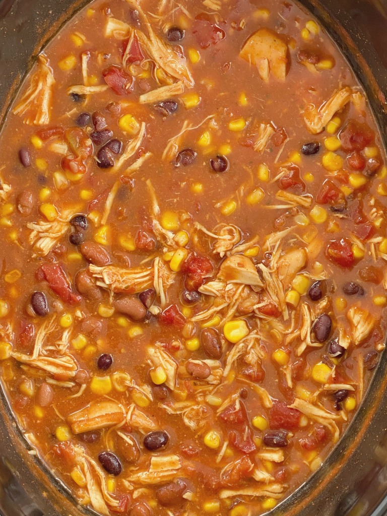 Taco Ranch Chicken Chili cooks in the slow cooker and only needs a few pantry staple ingredients! It's a dump & go chili with chicken , vegetables, beans, and lots of flavor. No chopping or prep work needed for this easy chili recipe. 