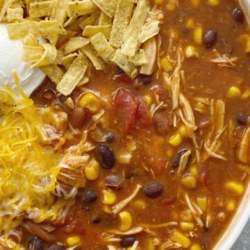 Taco Ranch Chicken Chili cooks in the slow cooker and only needs a few pantry staple ingredients! It's a dump & go chili with chicken , vegetables, beans, and lots of flavor. No chopping or prep work needed for this easy chili recipe.