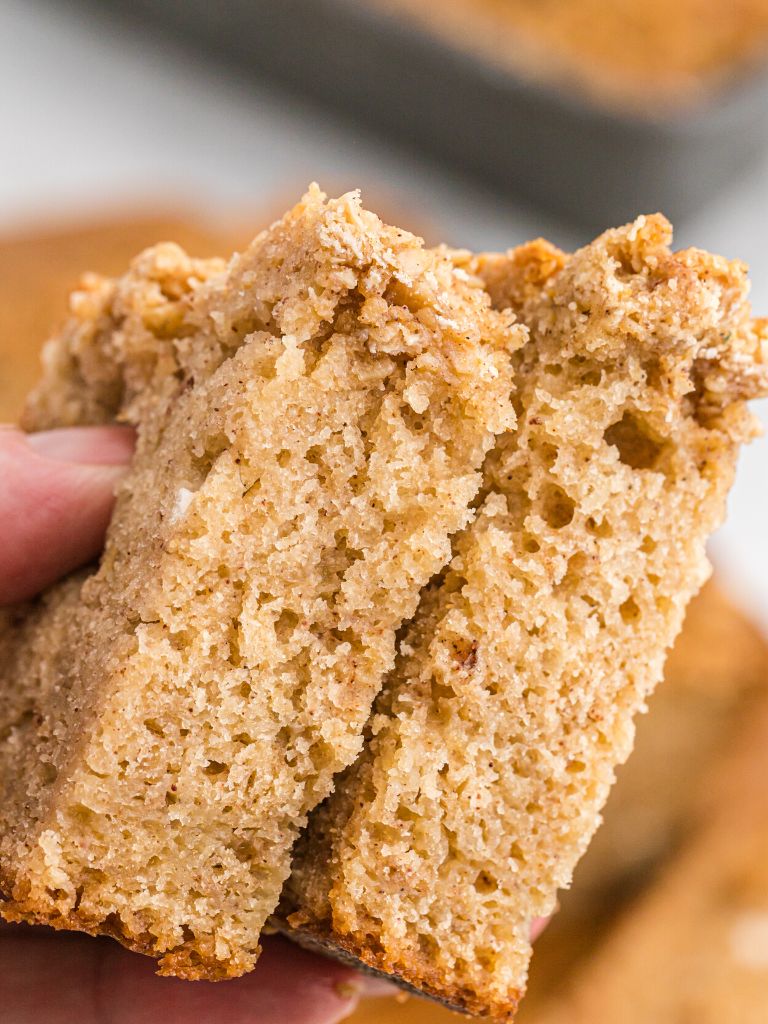 Two slices of applesauce bread being held by a hand. 