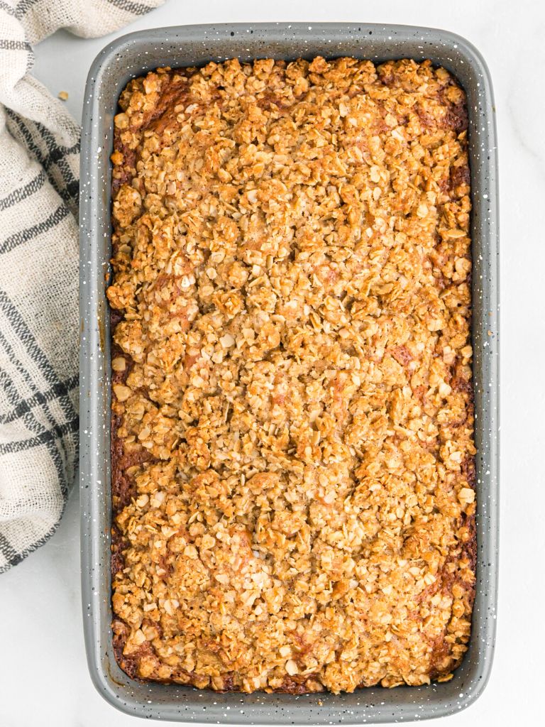 Overhead top view of a bread pan with bread inside and topped with a streusel crumble topping. 