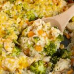 CHEESY CHICKEN AND RICE is made in only one skillet pan! Chunks of seasoned chicken, carrots, broccoli, and rice simmer in chicken broth. Sprinkle with cheese and serve this delicious dinner.