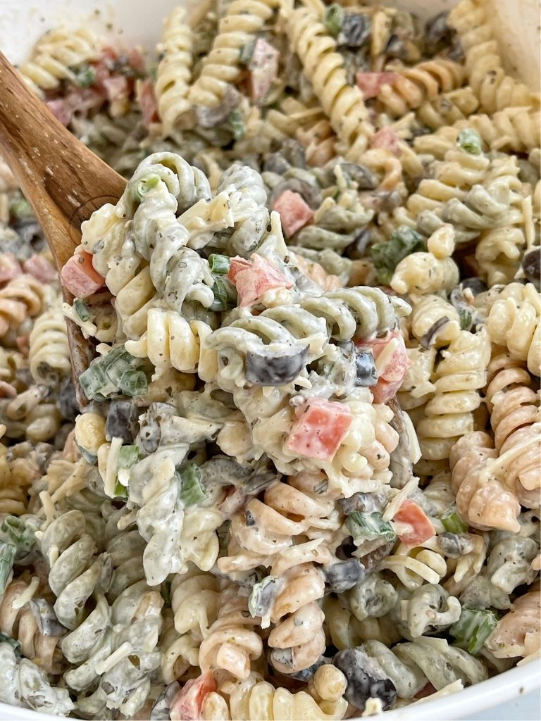 A wooden spoon with pasta salad on it.