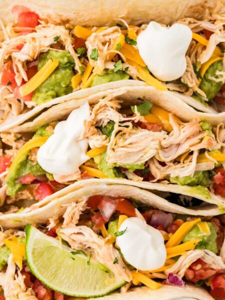 Closes up of the top of the tacos with shredded chicken and all the toppings.