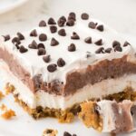 A slice of the layered pudding dessert on a plate with a fork.