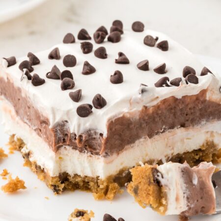 A slice of the layered pudding dessert on a plate with a fork.