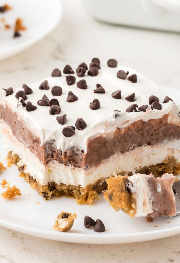 A slice of the layered pudding dessert on a plate with a fork.