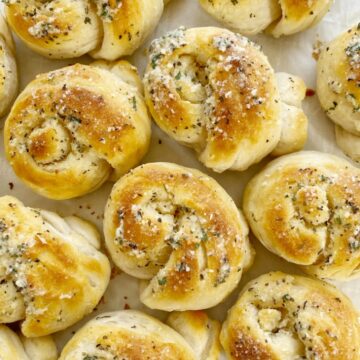 Easy Parmesan Garlic Knots are so simple to make with biscuit dough, melted butter, and seasonings! So buttery, flaky, fluffy, and soft. They can be ready in only 15 minutes.