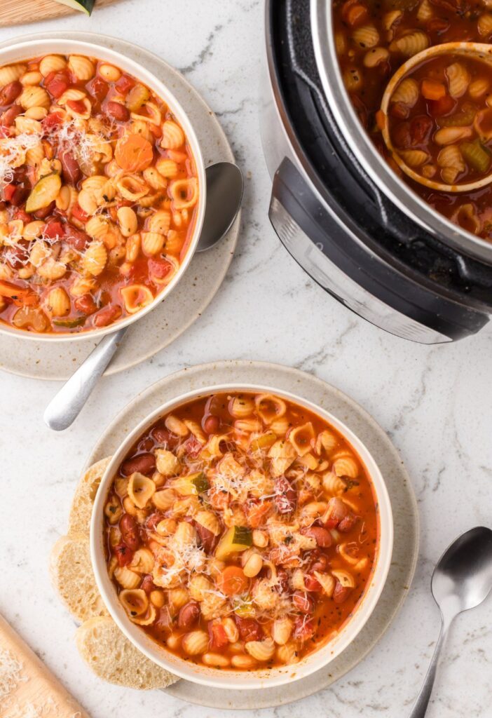 Overhead pic of the instant pot with bowls of the minestrone soup.