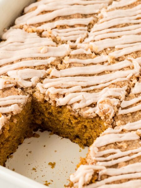 A pan of the cake with a piece taken out of it.