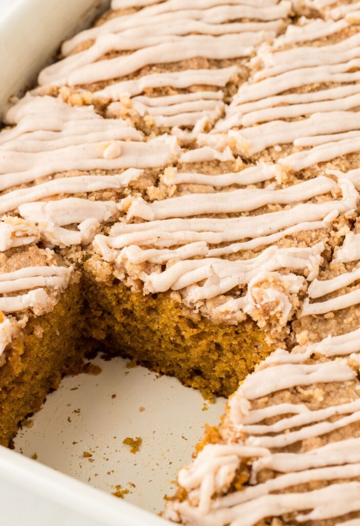 A pan of the cake with a piece taken out of it. 