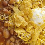 Crockpot Chili is sweet & spicy and so good served with sour cream, cheese, and Fritos. Made with three different beans, ground beef, tomato sauce, beef broth, seasonings, and my favorite chili ingredient ... cocoa powder!