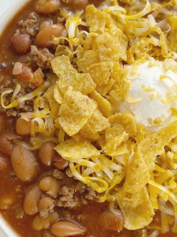 Crockpot Chili is sweet & spicy and so good served with sour cream, cheese, and Fritos. Made with three different beans, ground beef, tomato sauce, beef broth, seasonings, and my favorite chili ingredient ... cocoa powder!