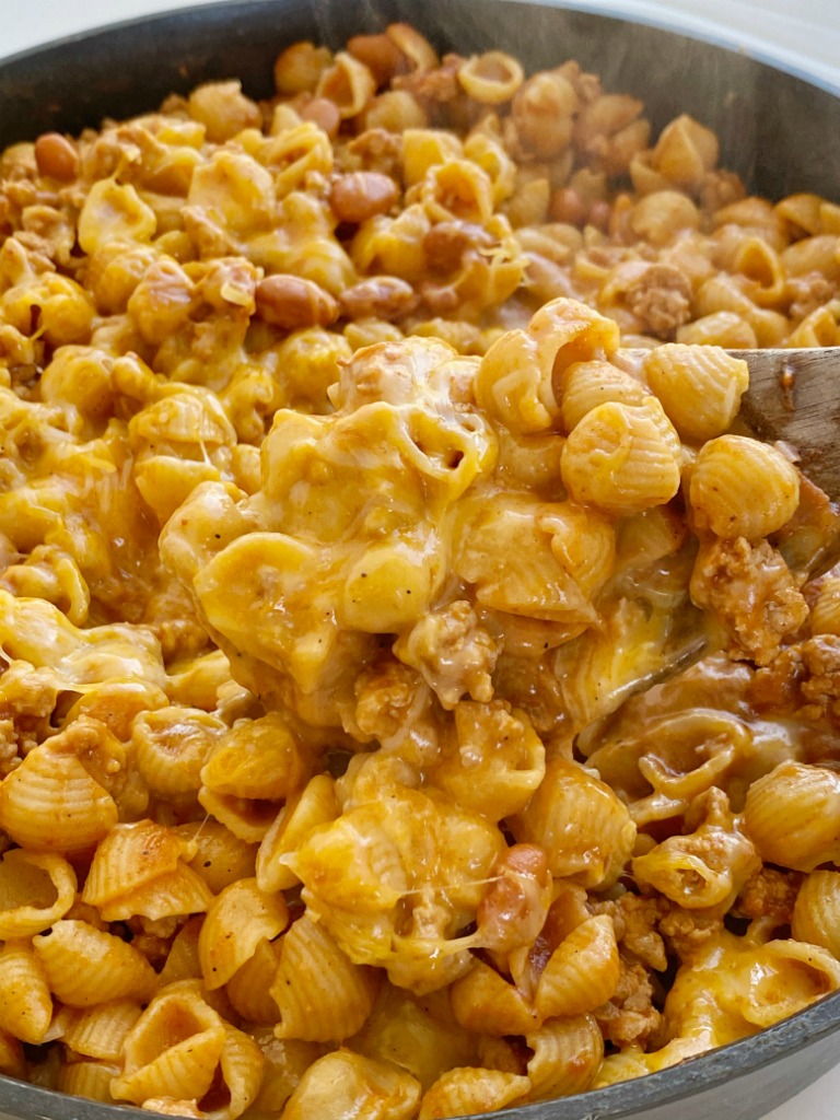 Turkey Chili Mac and Cheese is made in just one pot! Ground turkey chili with pinto beans cooks in a seasoned tomato sauce and chicken broth base with small shell pasta. Add lots of cheese for a cheesy and creamy mac and cheese with turkey chili!