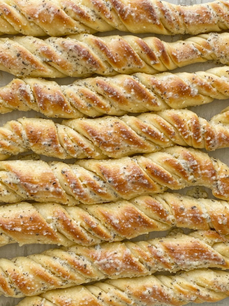 Easy Breadsticks Recipe are a family favorite because of their fun twisty shape. Quick & easy to make and the perfect recipe for beginners. Soft breadsticks filled with garlic butter and topped with parmesan seasoned butter. 