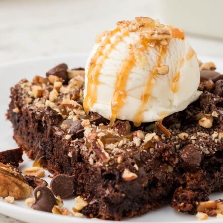 A serving the dump cake with caramel and ice cream.