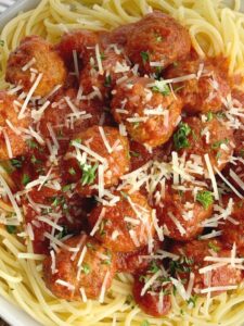 meatballs and pasta sauce garnished with parmesan cheese