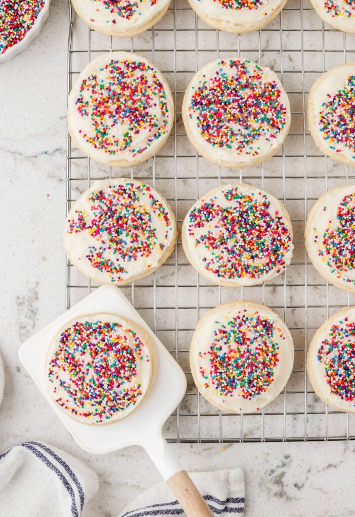 A cooling rack with cookies on it and a spatula