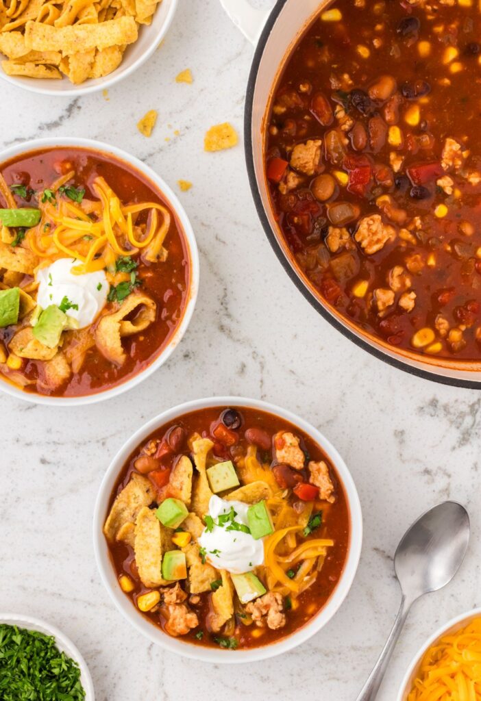 Pot of soup with bowls of the chili taco soup in it
