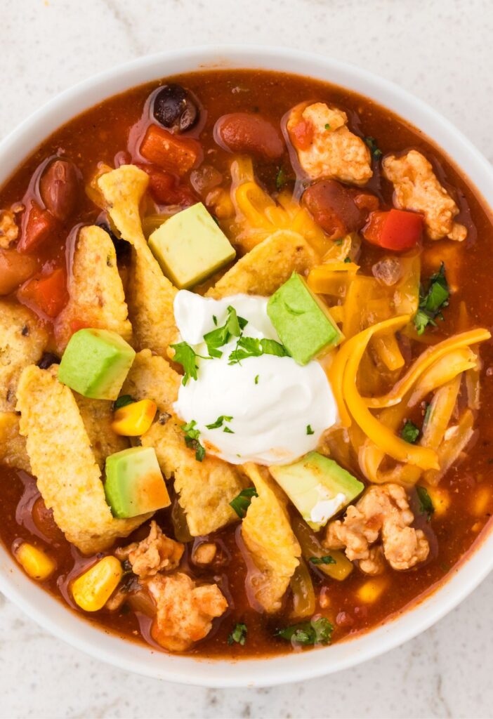 Bowl of chili taco soup with ground turkey and toppings.