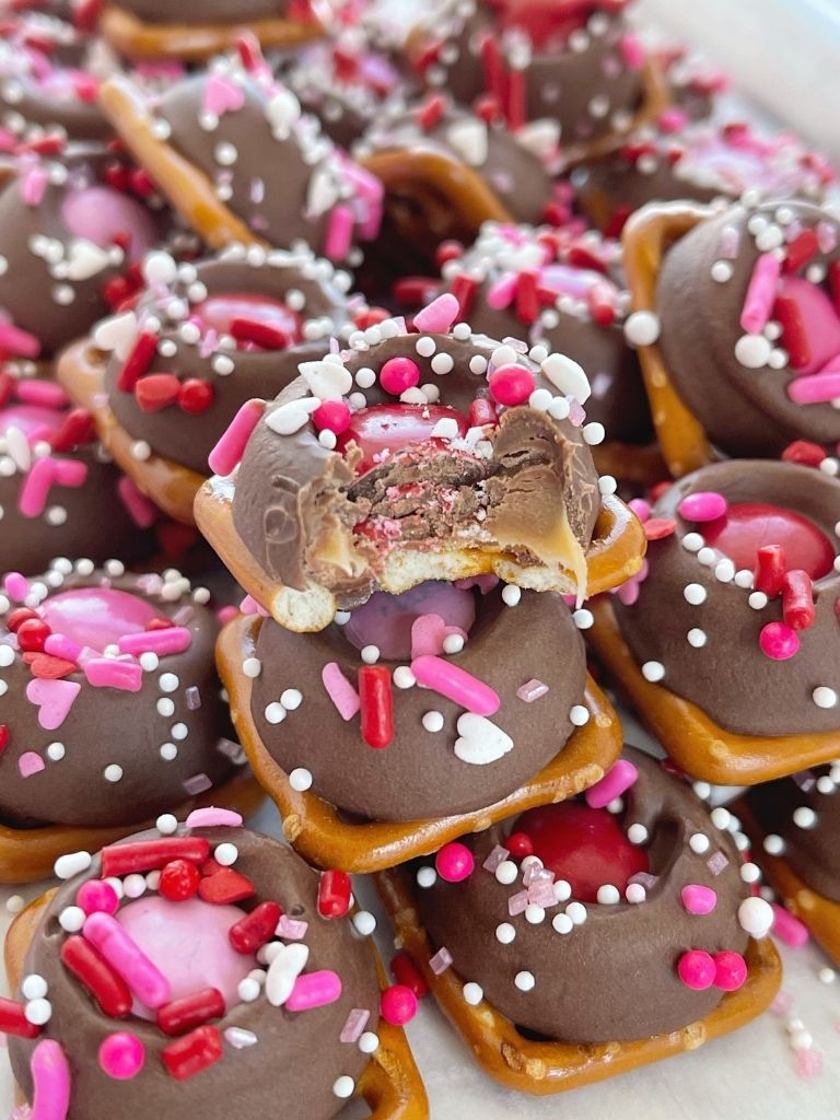 Caramel Pretzel Bites recipe with a Valentine's Day twist. Pretzel, caramel Rolo candy, m&m's, and heart shaped sprinkles. 