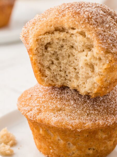 Stack of two muffins with the top having a bite taken out of it to show the soft middle.