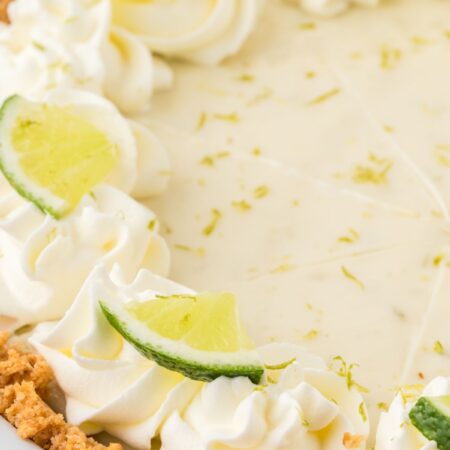 Side view of the key lime pie in a graham cracker crust and whipped cream on top.