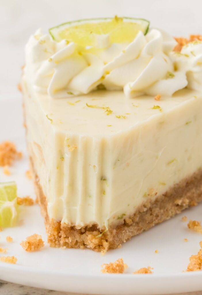 A slice of key lime pie with a fork bite taken out of the front.
