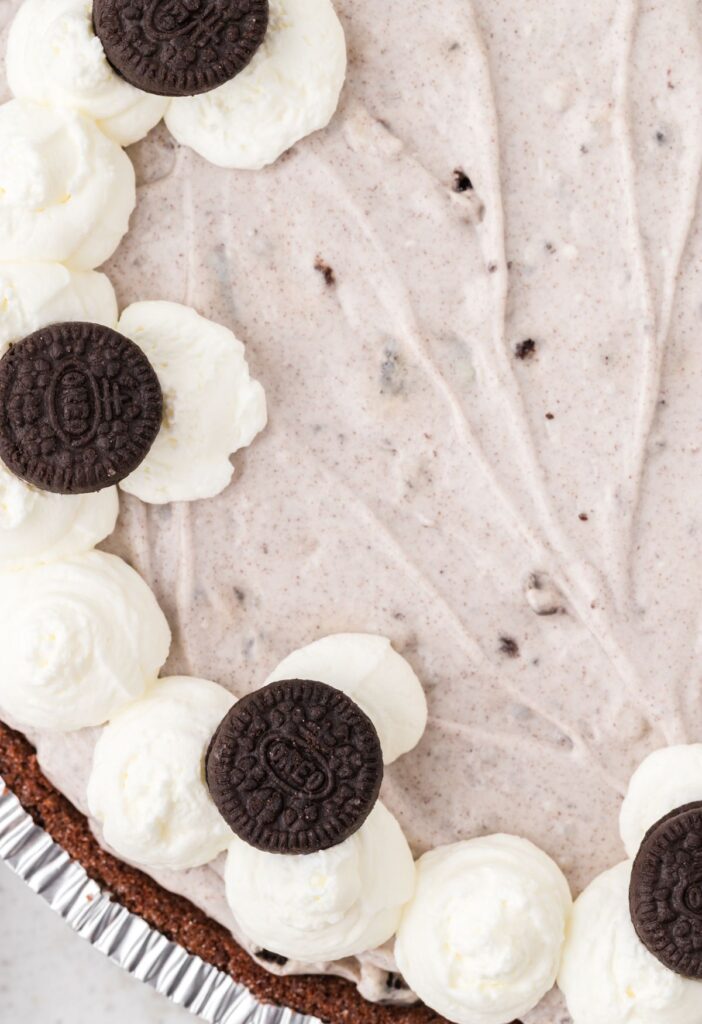 Close view of the Oreo pudding pie with whipped cream and mini Oreo cookies on top. 