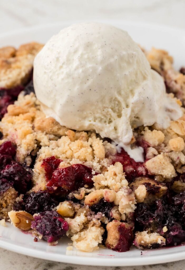 A white plate with the frozen berry crisp on it