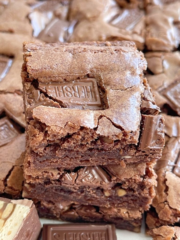 A picture of a candy bar brownies with chunks of candy bar showing. 