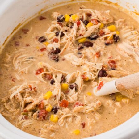 A white crock pot with the cream chicken mixture for the mexican haystacks in it.