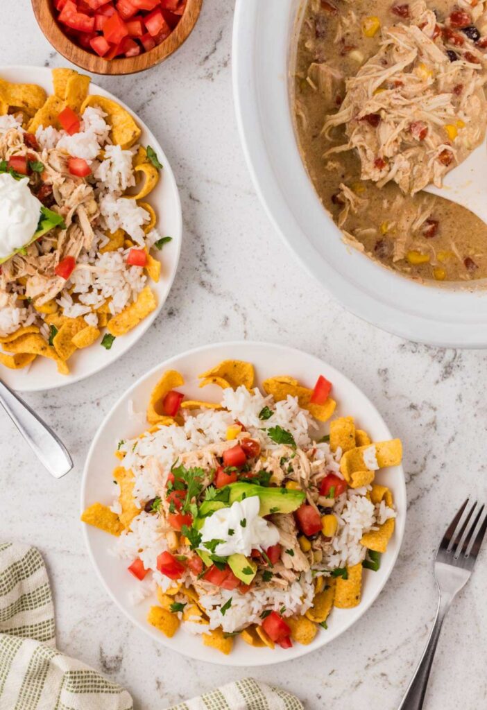 Top view of a serving of the mexican haystack and the crockpot of the creamy chicken mix