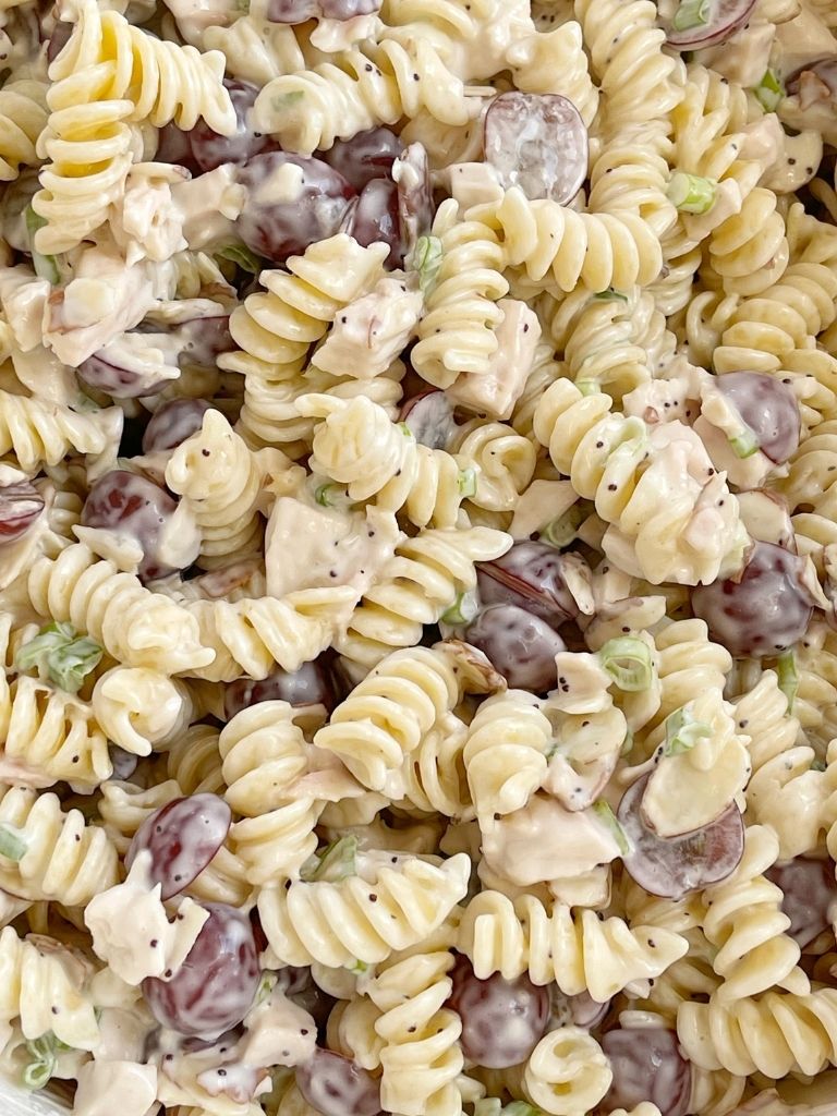 A close up picture of poppy seed chicken pasta salad with grapes in it. 