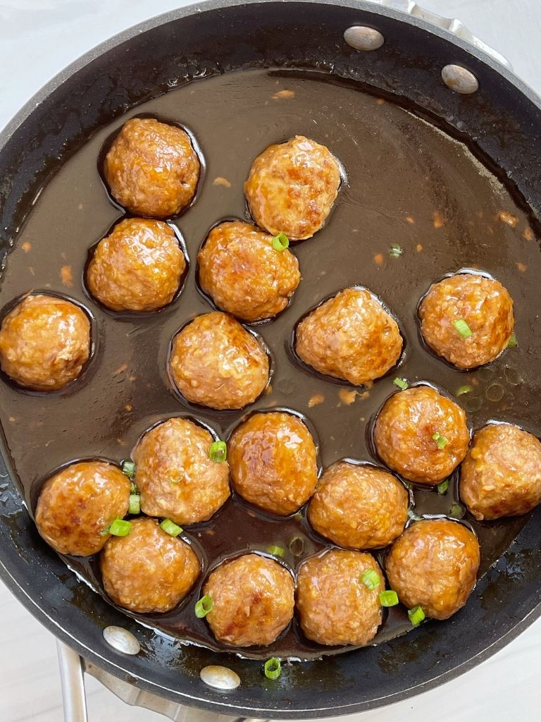 Meatballs in sauce inside a skillet pan.