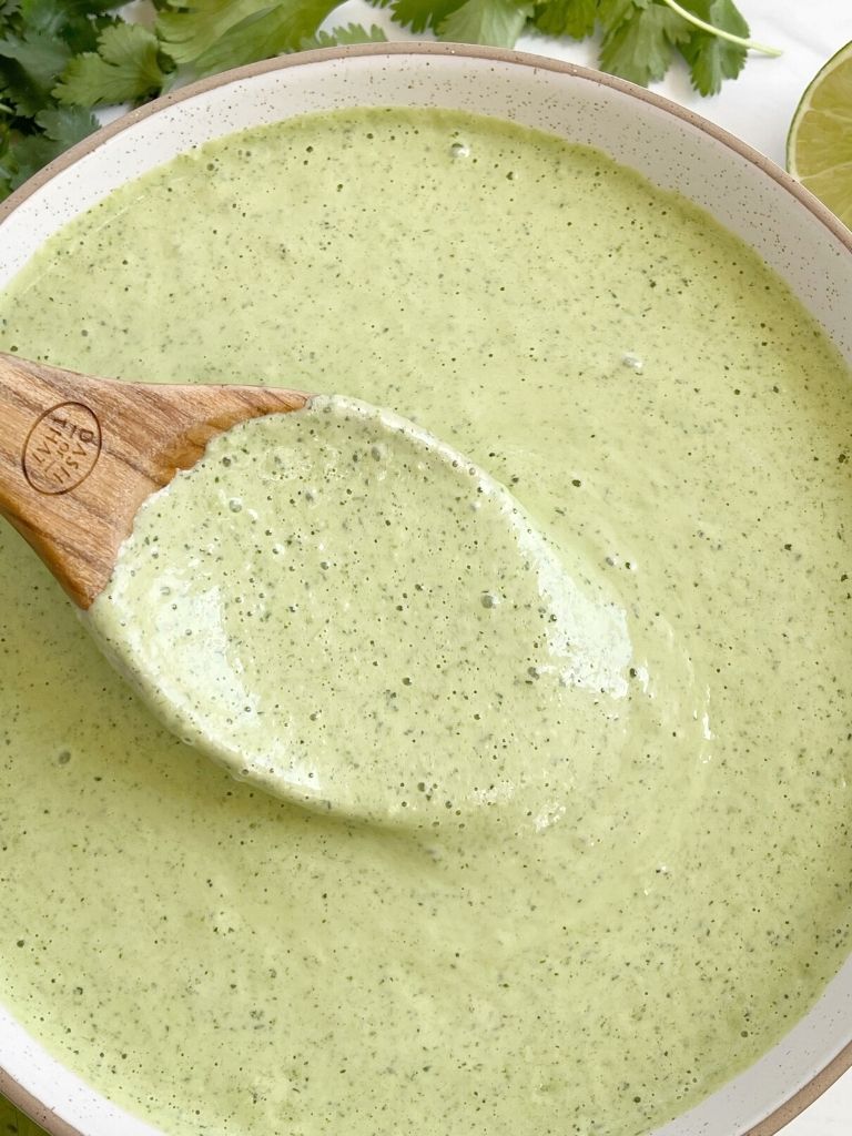 A spoon full of Cafe Rio dressing with cilantro on the side of the picture. 