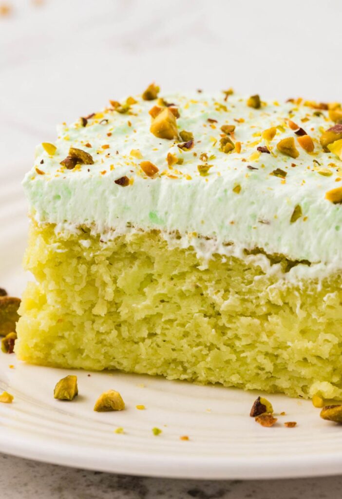 A slice of pistachio cake with pistachio frosting