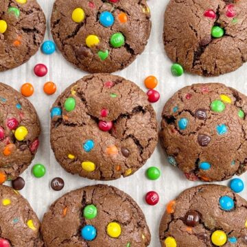 An overhead shot of a tray of chocolate mm cookies with mm candy on the sides of the pan.