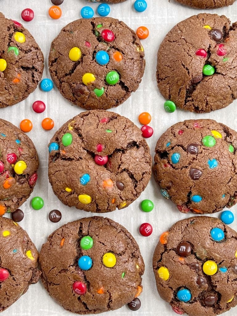 An overhead shot of a tray of chocolate mm cookies with mm candy on the sides of the pan. 