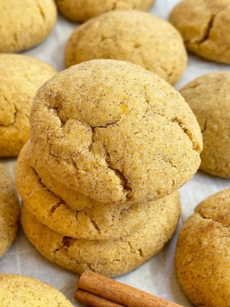 Pumpkin snickerdoodle cookies on a cookie sheet with parchment paper. 