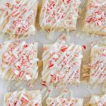 Overhead shot of squares of peppermint fudge on a white background.