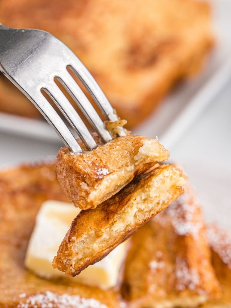 Close up of a piece of French toast on a fork