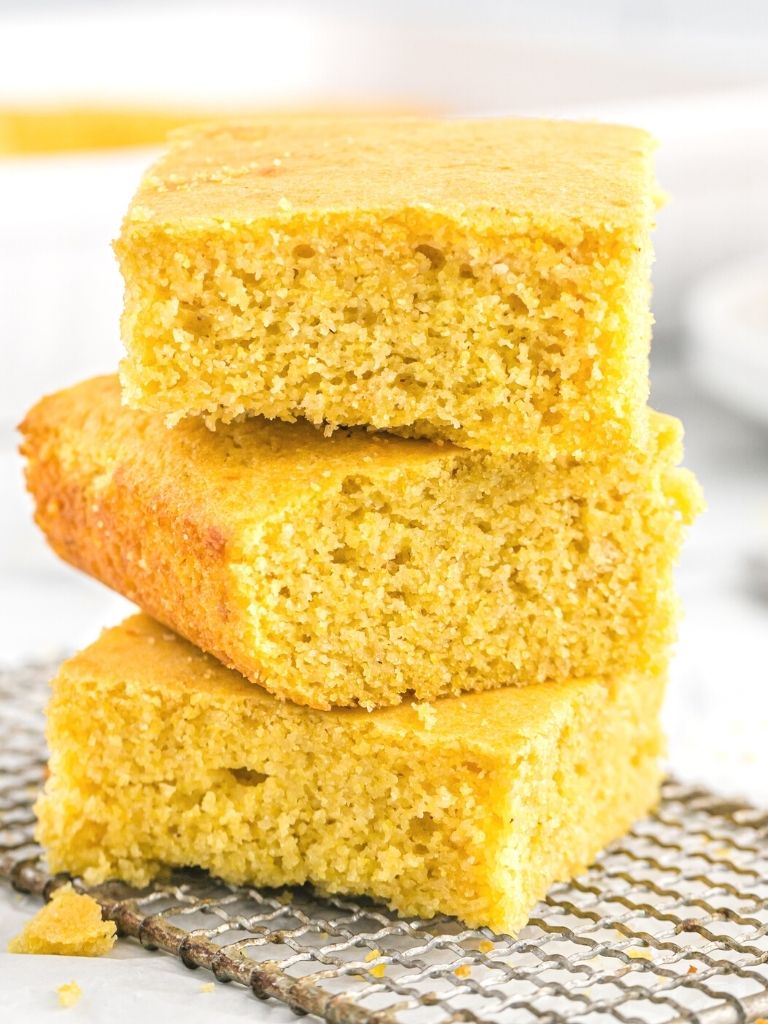 Stack of three pieces of cornbread on top of a wire cooling rack.