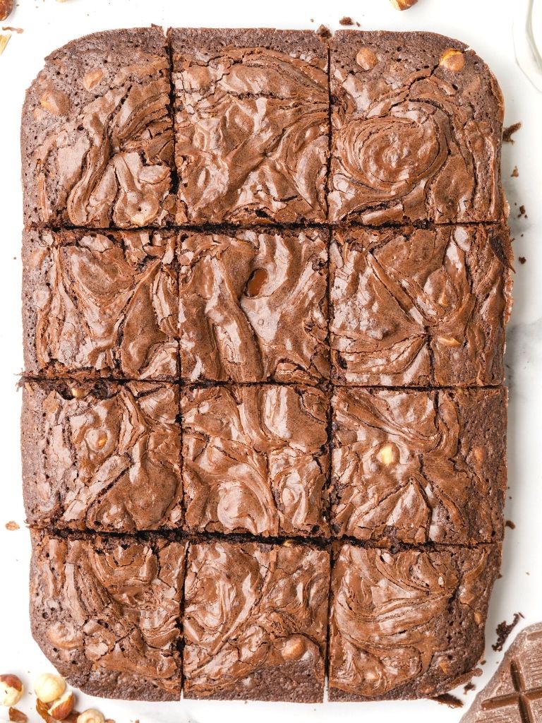 Overhead shot of sliced brownies on a white background. 