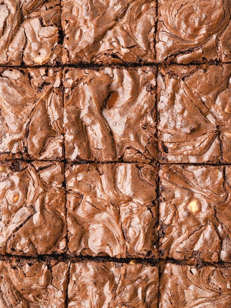 Overhead picture of a pan of sliced brownies with Nutella swirls on top. 
