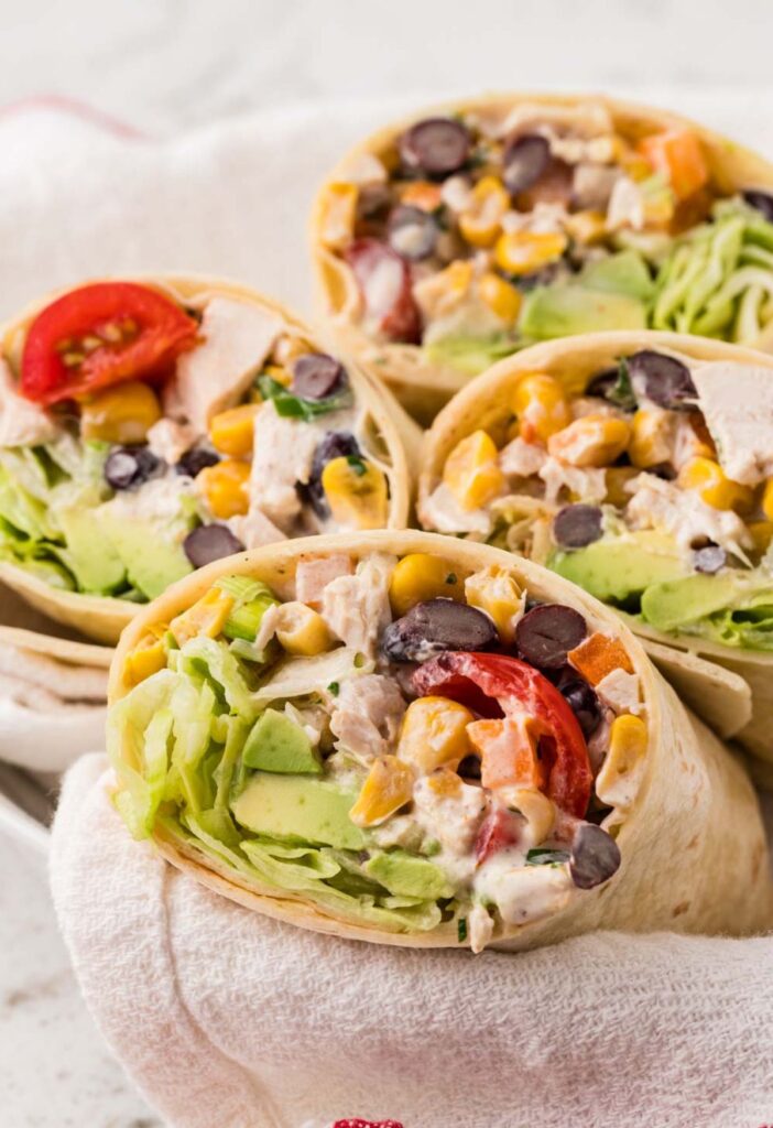Chicken salad wraps inside a basked lined with a towel.